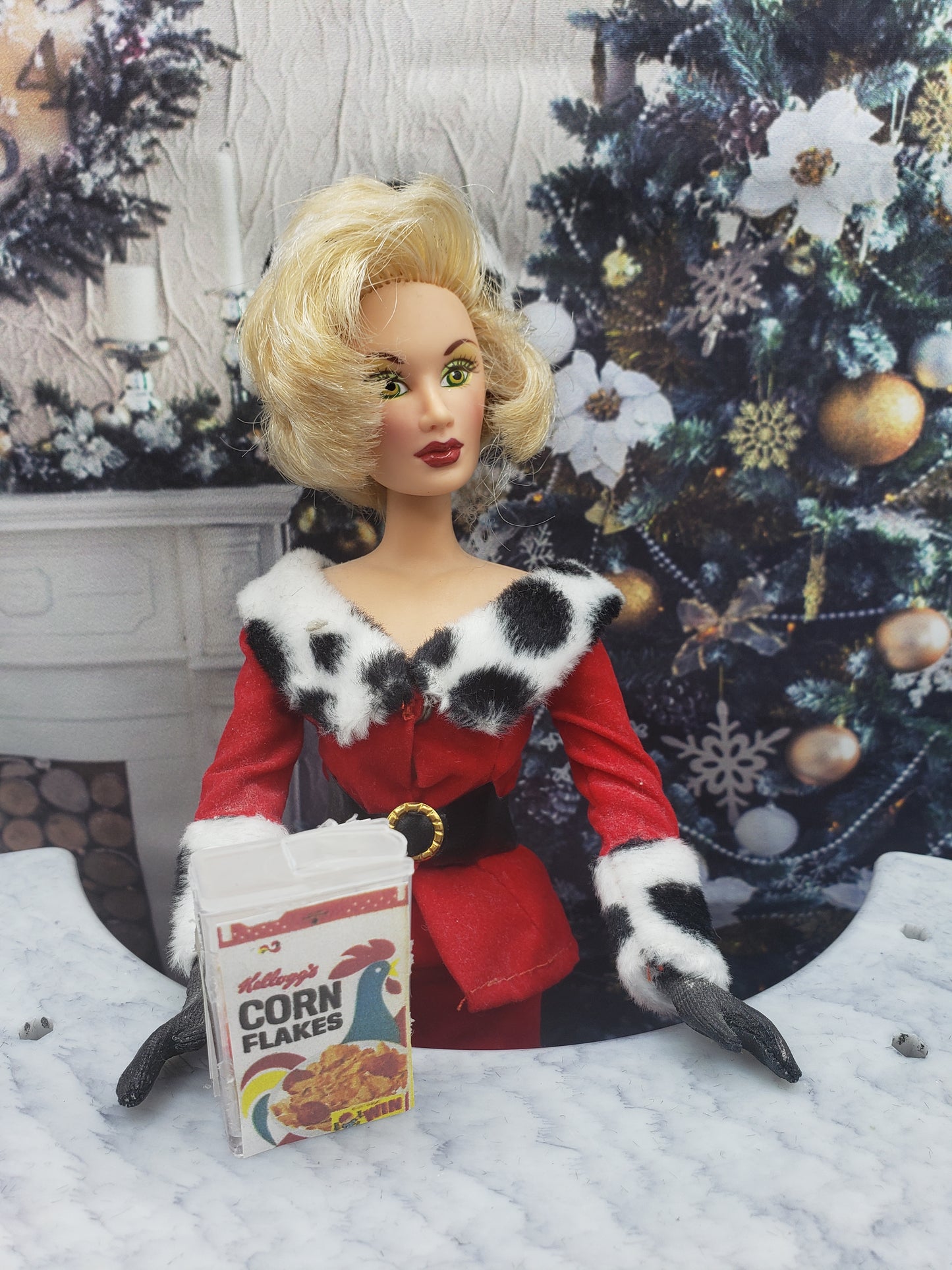 Miniature corn flakes for dolls box beside doll dressed in festive red outfit near Christmas tree