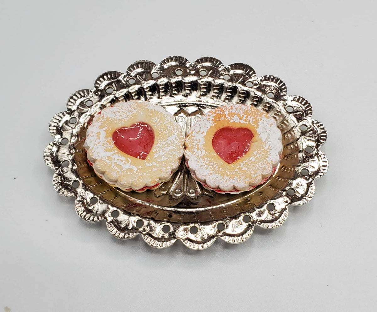 Chef Gina's mini Linzer cookies dolls with powdered sugar and red jam center on silver tray