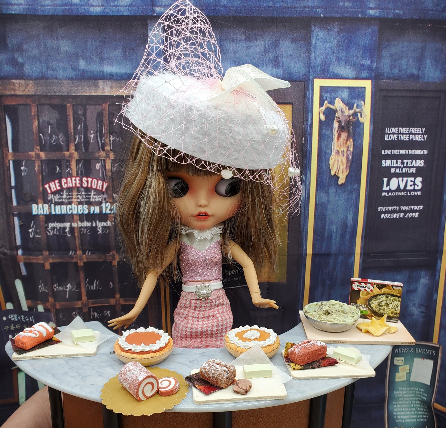 Blythe doll with pink dress and hat showcasing a miniature pumpkin roll for dolls at a dessert table
