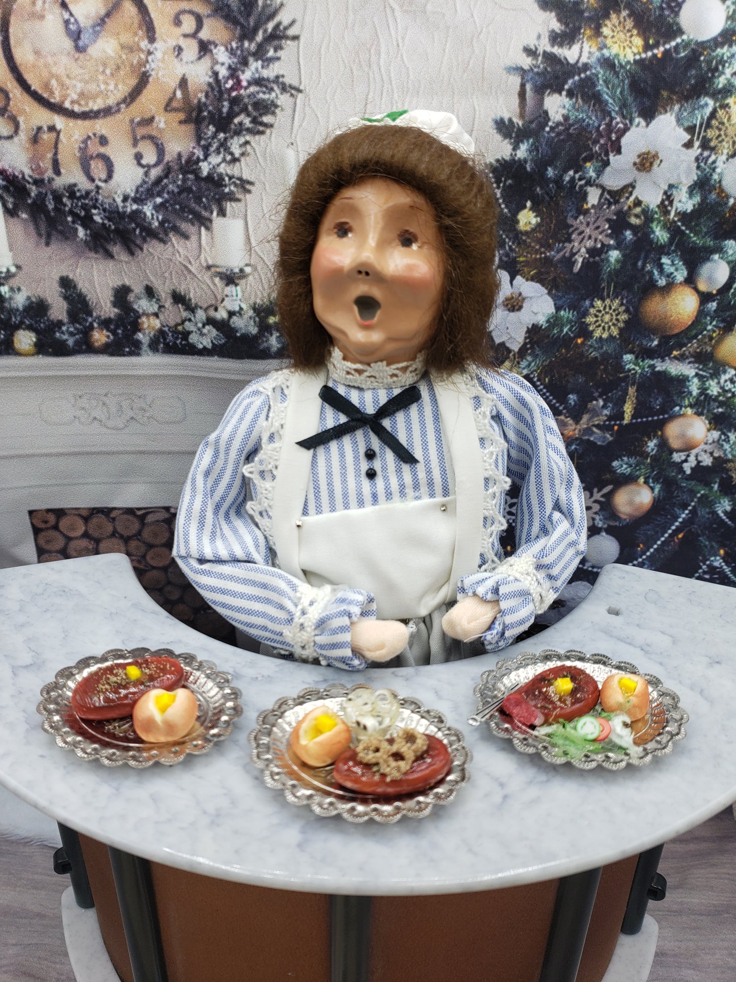 Miniature steak dinner set with three small plated entrees displayed in front of a doll figure from Chef Gina's Mini Food