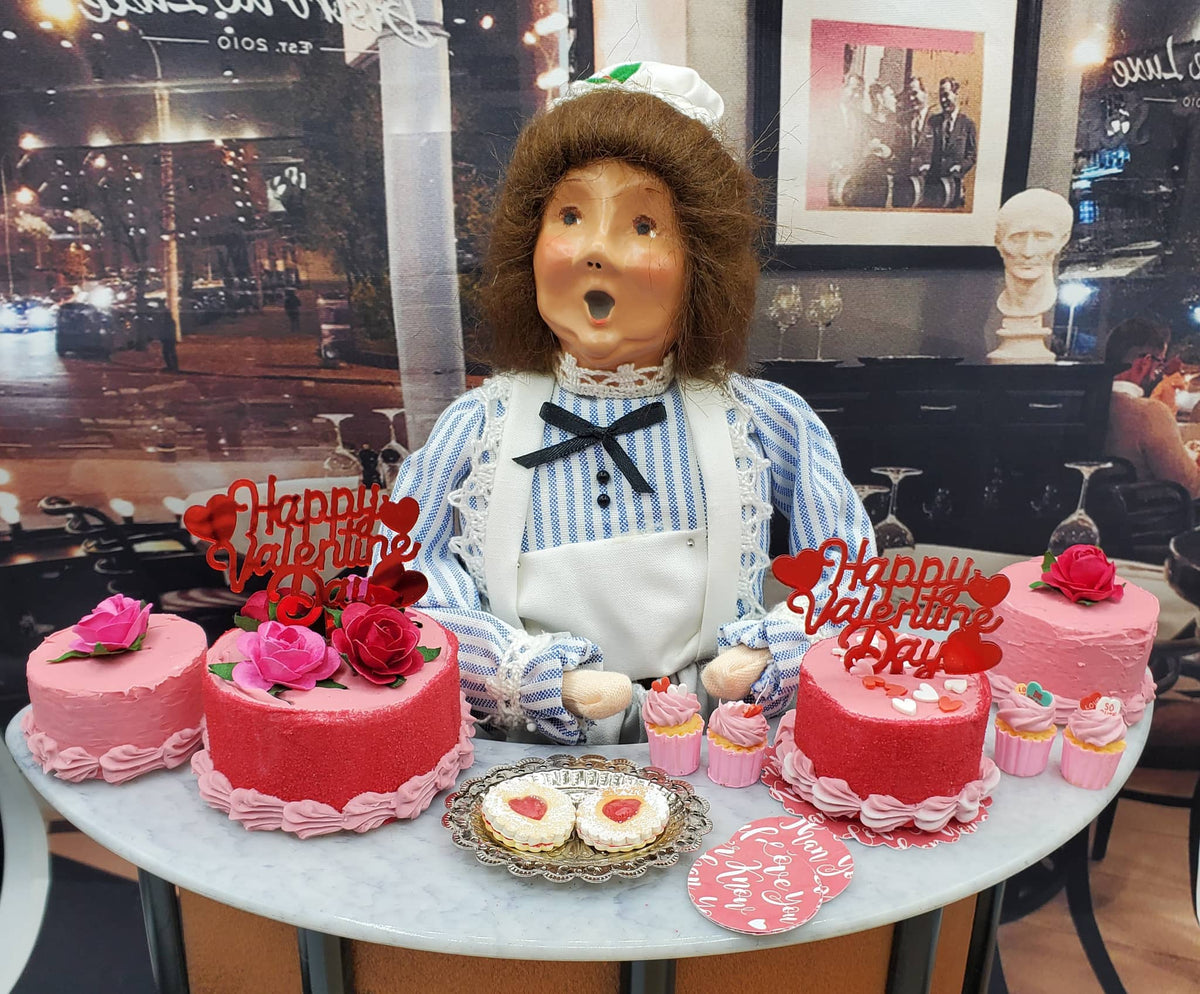 Chef Gina's miniature Valentine's cupcakes and pink cakes with Happy Valentine signs on a table with a doll display