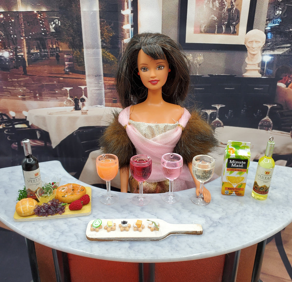 Miniature white wine for dolls displayed at a table setting with a doll and food accessories