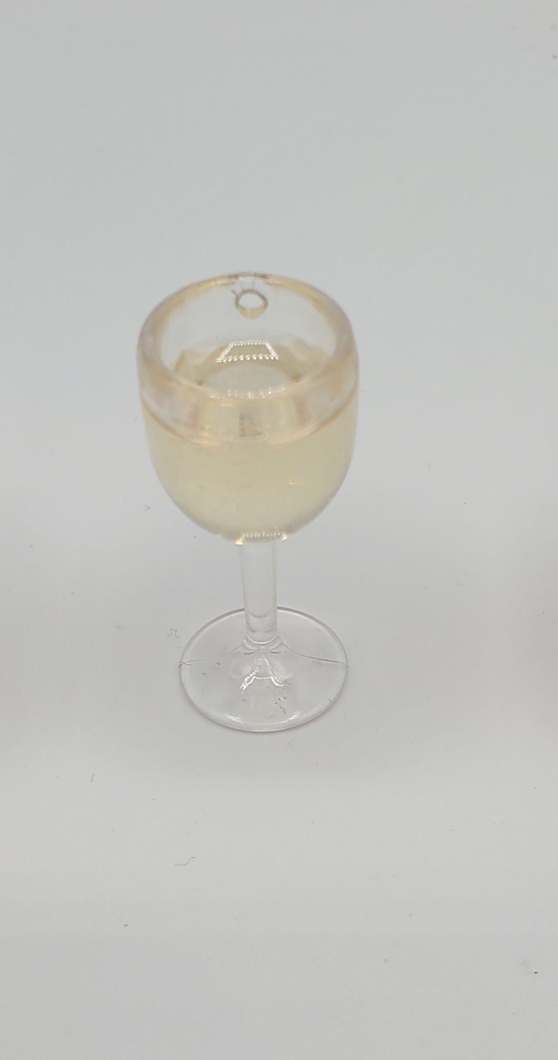 Chef Gina's miniature white wine for dolls in a clear glass with white liquid inside