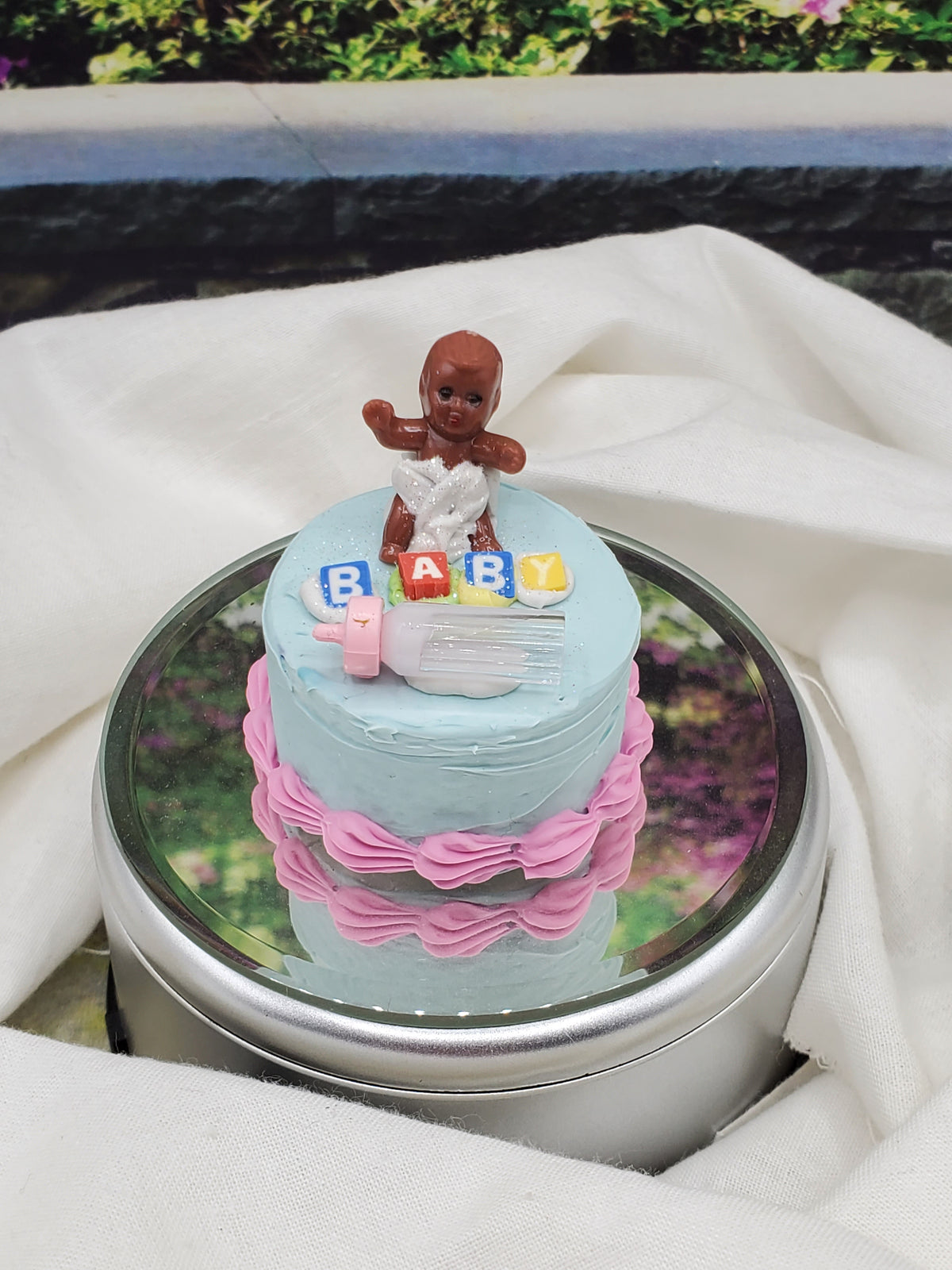 Chef Gina's one sixth scale baby cake with a baby figure and pastel blue and pink frosting