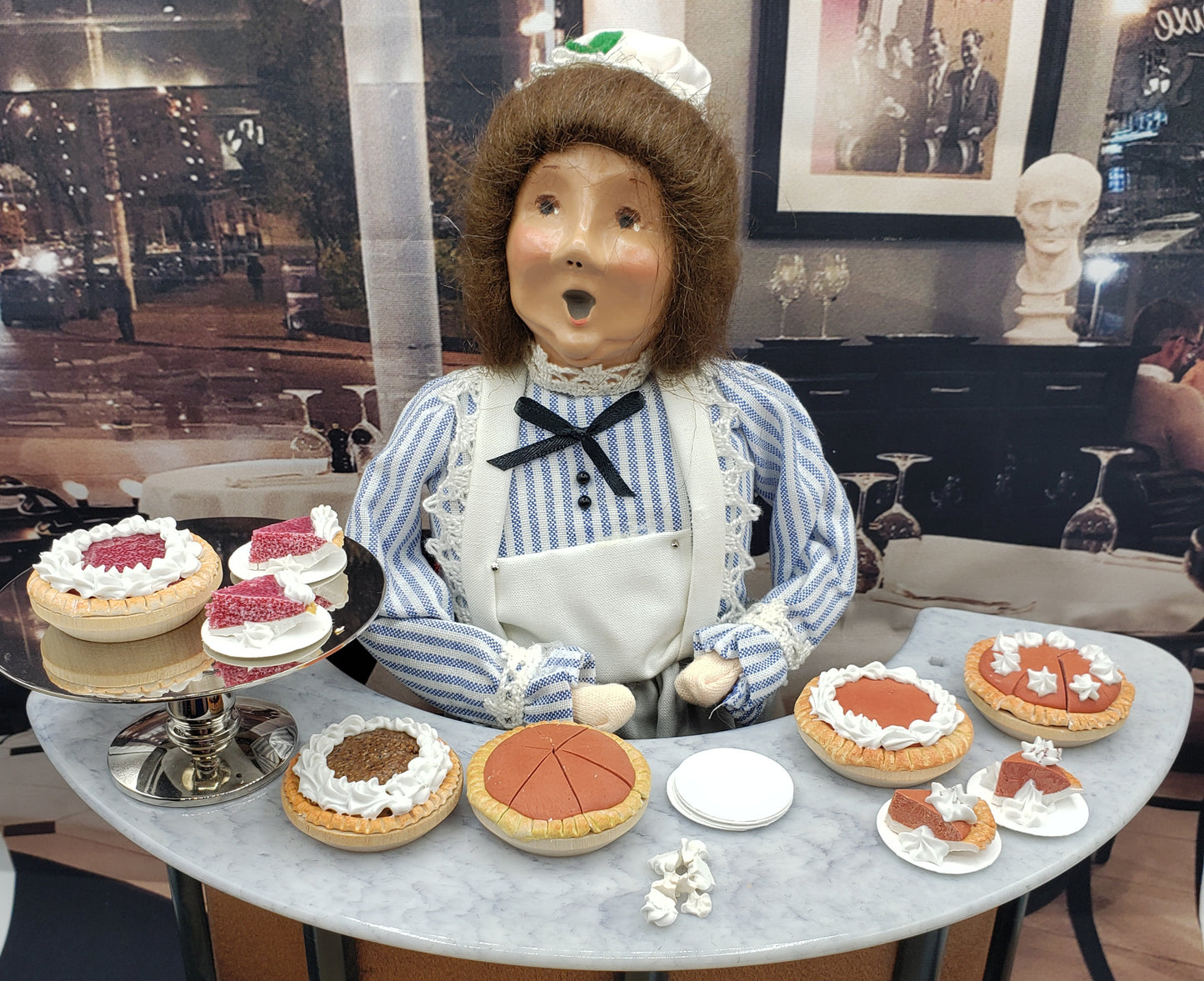Chefginas dessert display featuring pumpkin pie for doll displays among various cakes and pastries