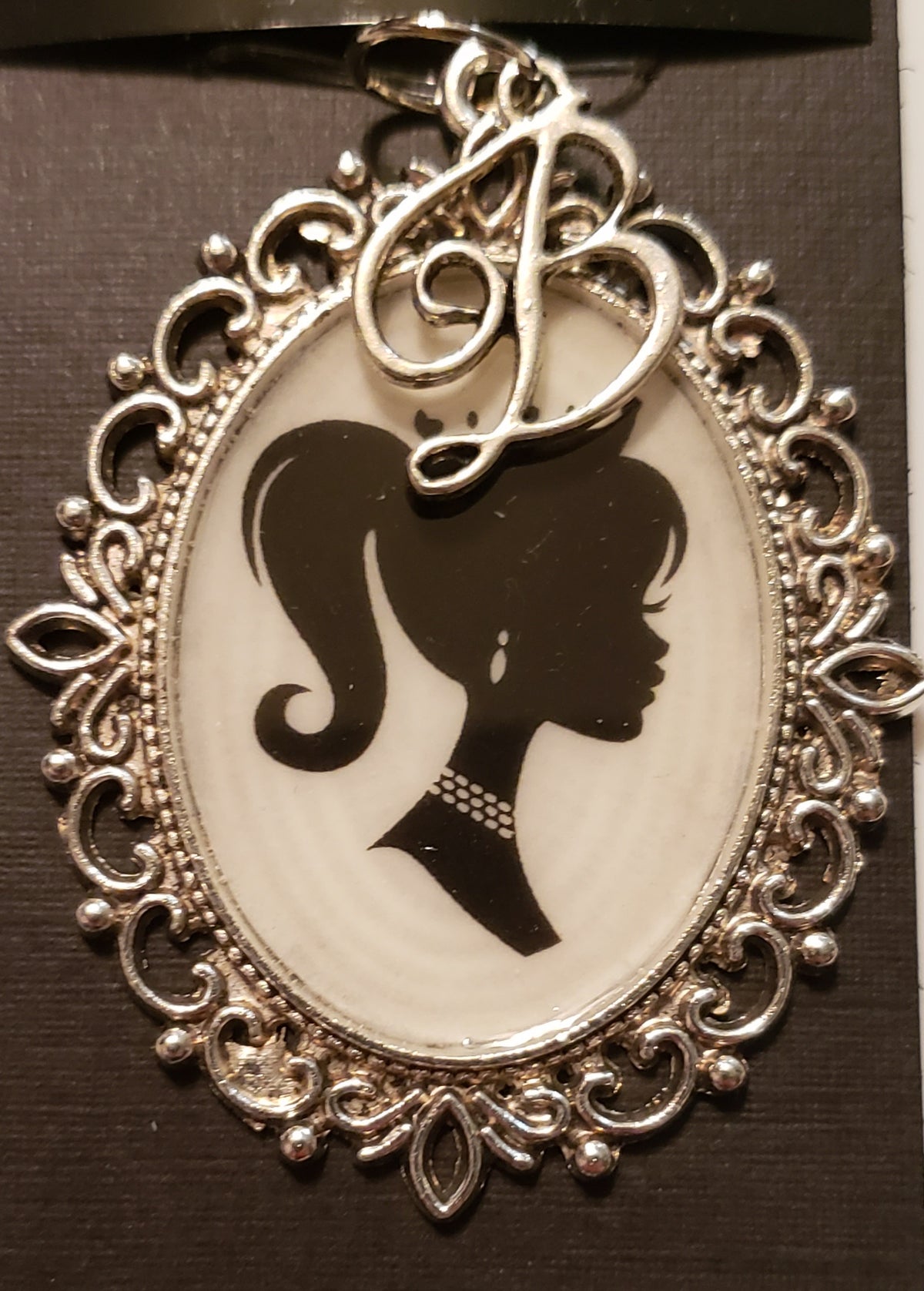 Silver ornate pendant with silhouette of Barbie and script B in Barbie necklace set