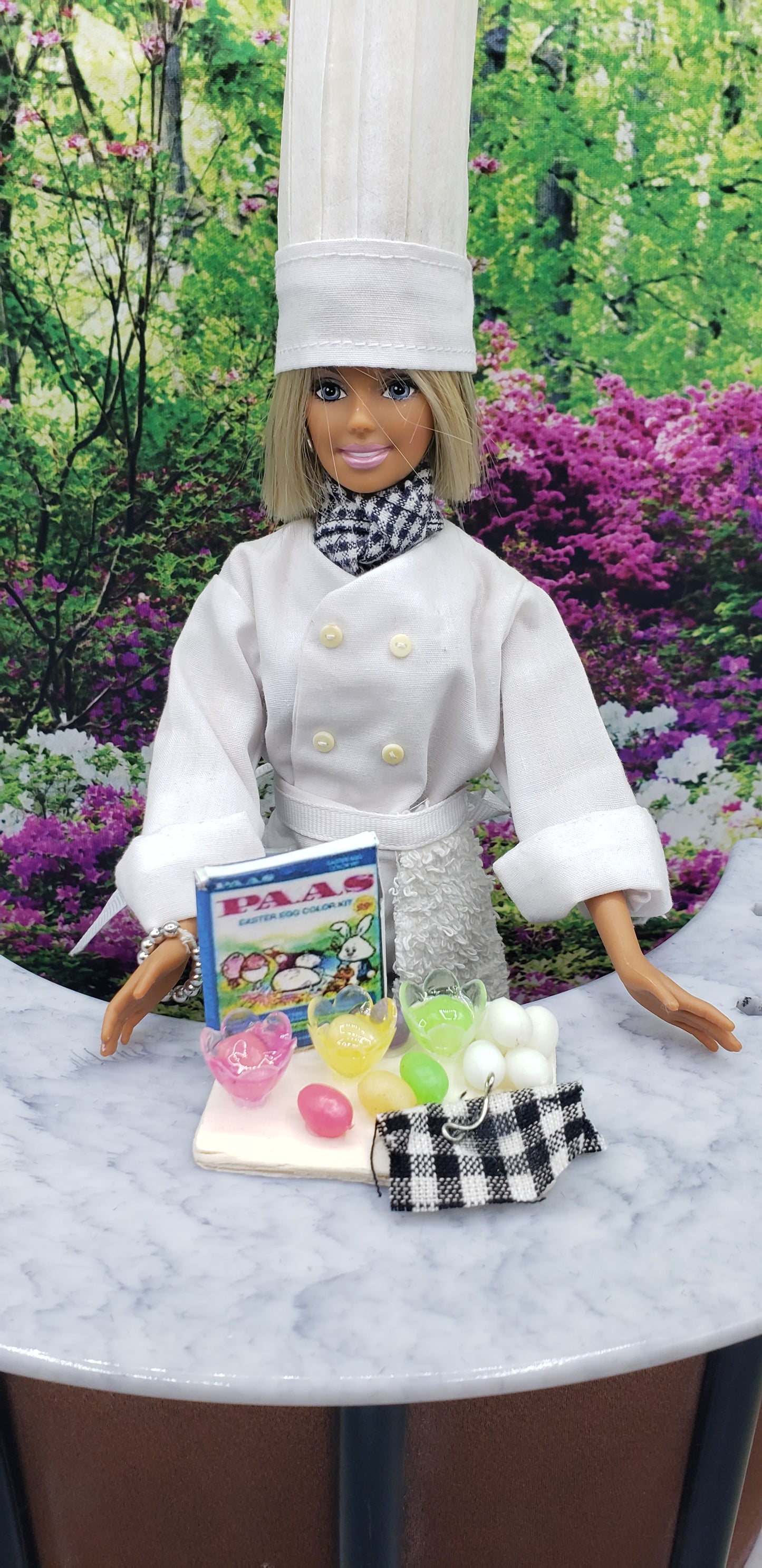 Fashion doll dressed as a chef with accessories for fashion doll egg decorating kit on marble table