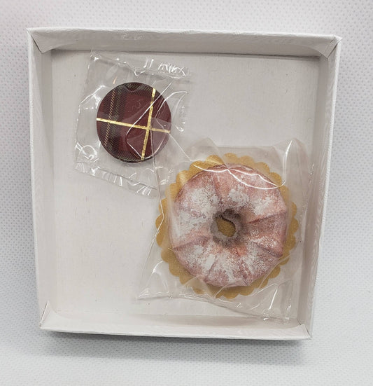 Chef Gina's miniature bundt cake doll food in clear packaging with a small chocolate accessory in a white box