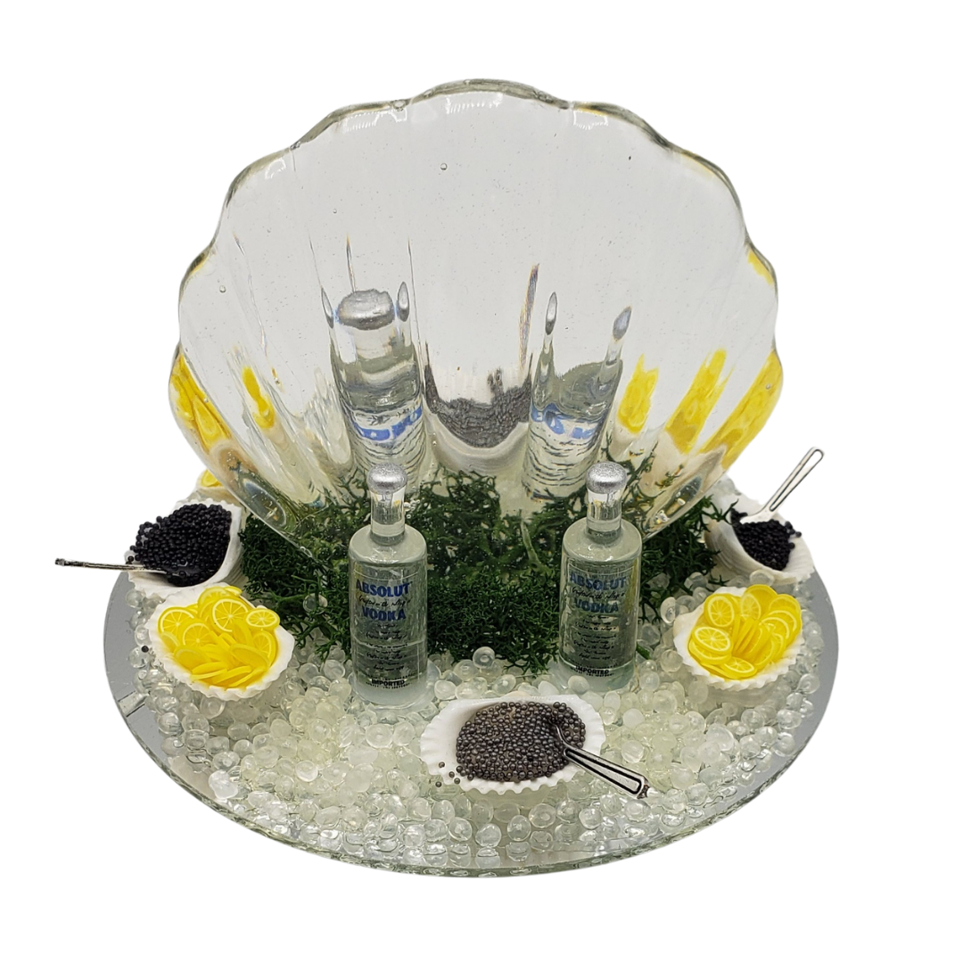 Elegant miniature ice carving sculpture with seafood, caviar, lemon, and vodka display for hors d'oeuvres
