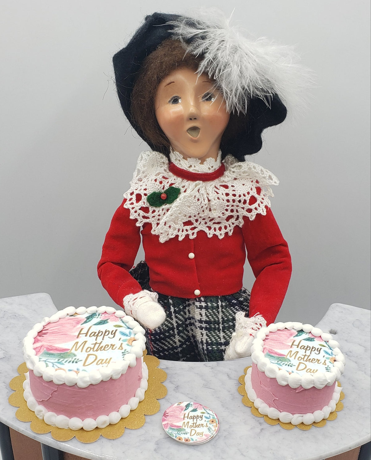Miniature Mother's Day cake displayed with a decorative doll in a festive outfit