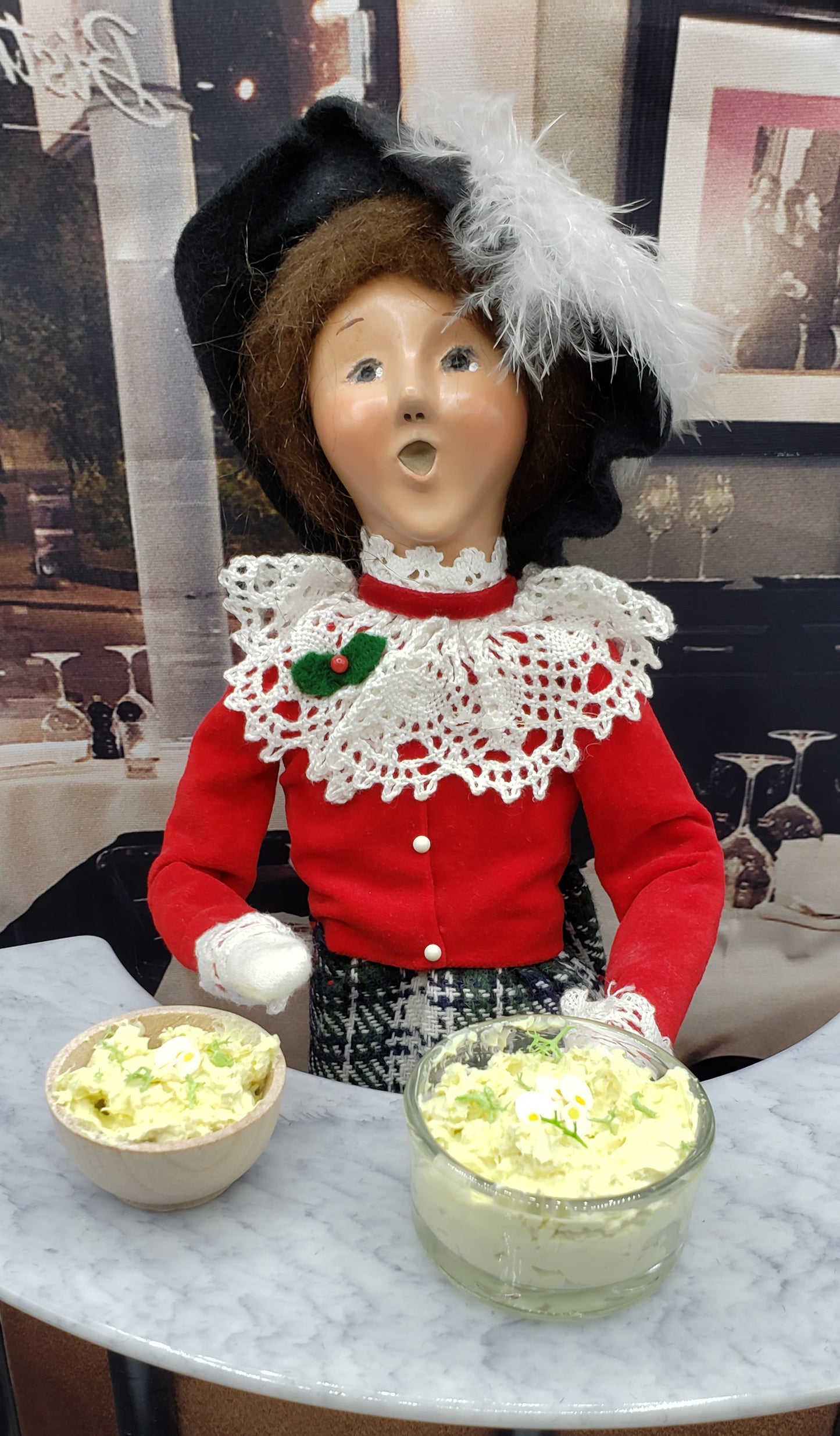 Miniature potato salad bowl displayed with a vintage doll in a restaurant setting