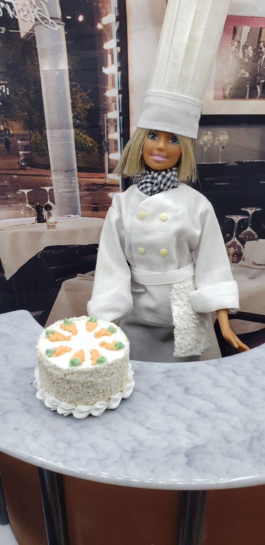 Chef doll presenting a realistic doll food carrot cake decorated with orange carrots on a marble countertop