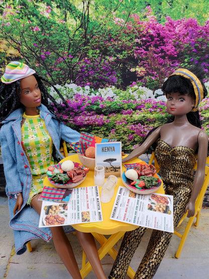 Two dolls seated at yellow table with African Kenya mini food set dishes and menus outdoors