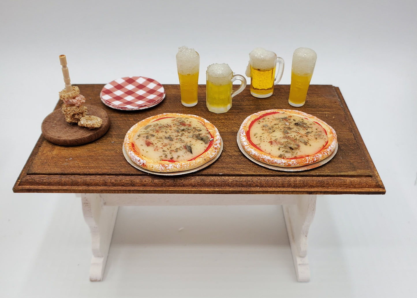 Chef Gina's Mini Food dollhouse beer and pizza party set with pizzas, beer mugs, plate, and skewers on wooden table