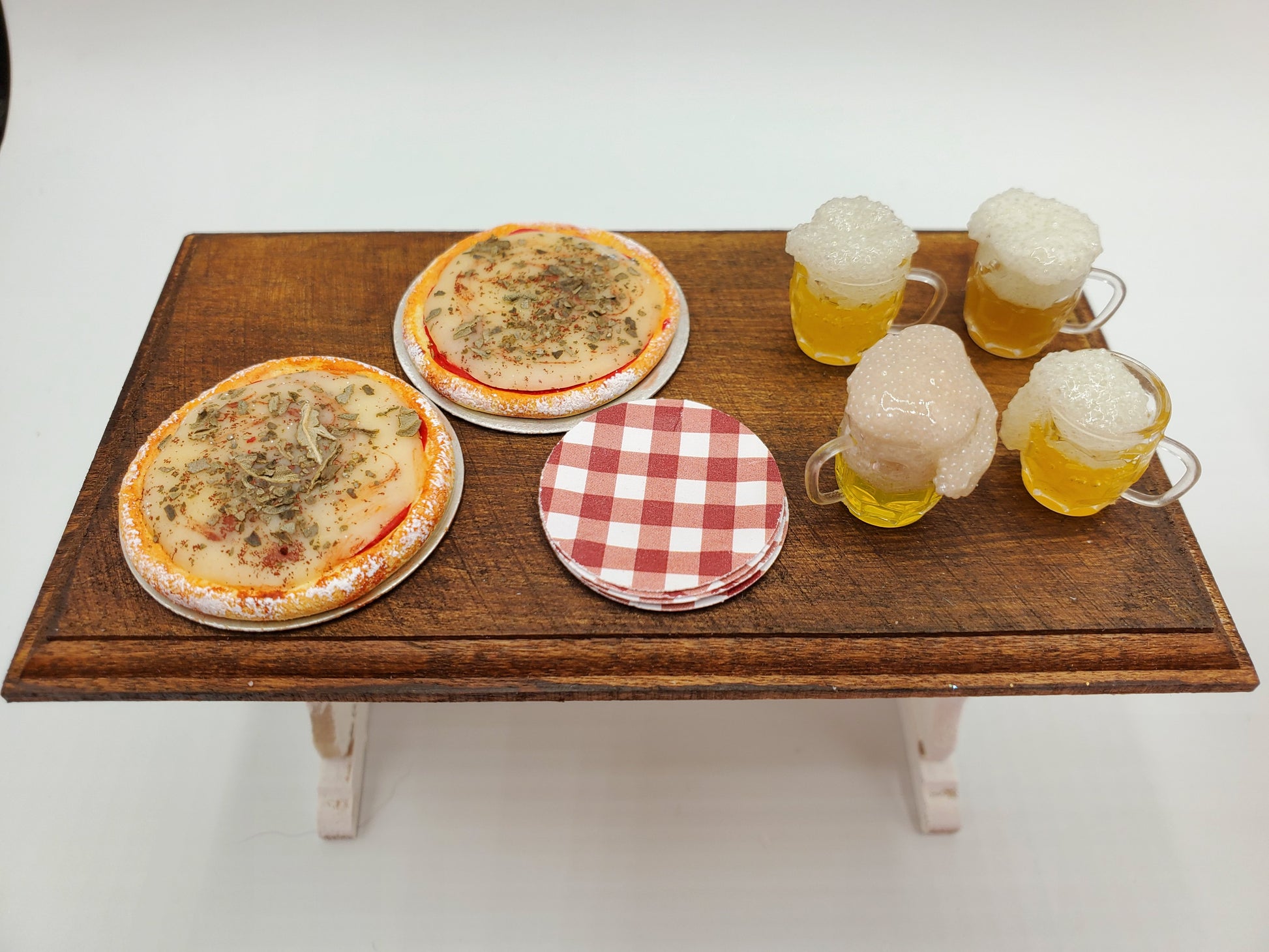 Chef Gina's Mini Food dollhouse beer and pizza party set with two pizzas, four foamy beer mugs, and coasters on wooden table