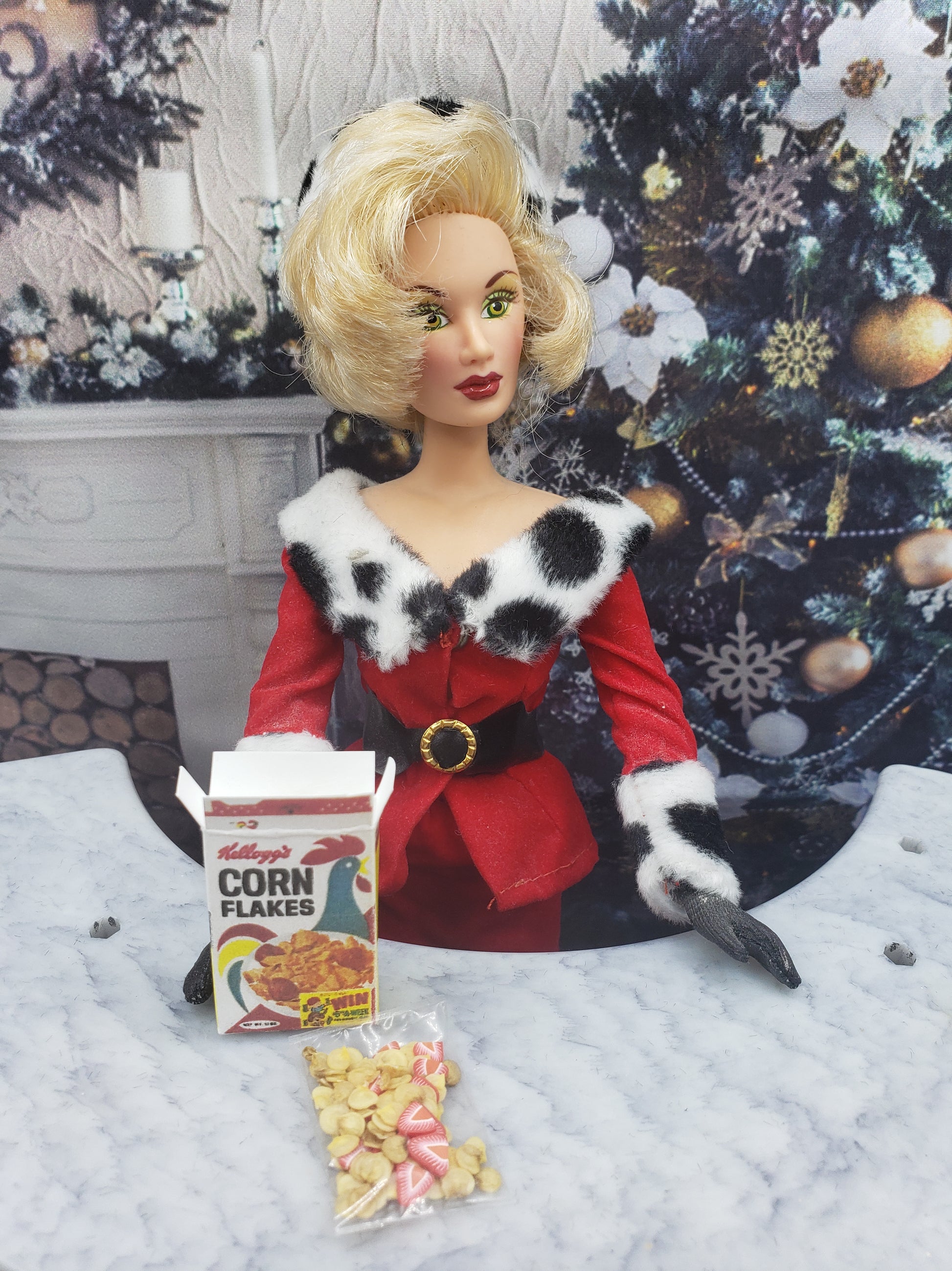 Chef Gina's miniature corn flakes for dolls box and cereal pieces displayed with a festive doll in holiday attire