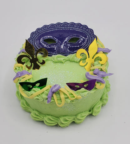 Chef Gina's Mardi Gras doll cake decorated with colorful masks and fleur-de-lis in green purple and yellow