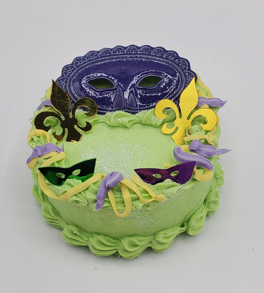 Chef Gina's Mardi Gras doll cake decorated with colorful masks and fleur-de-lis in green purple and yellow