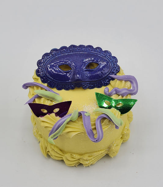 Chef Gina's Mardi Gras doll cake with yellow frosting and decorative purple and green masks