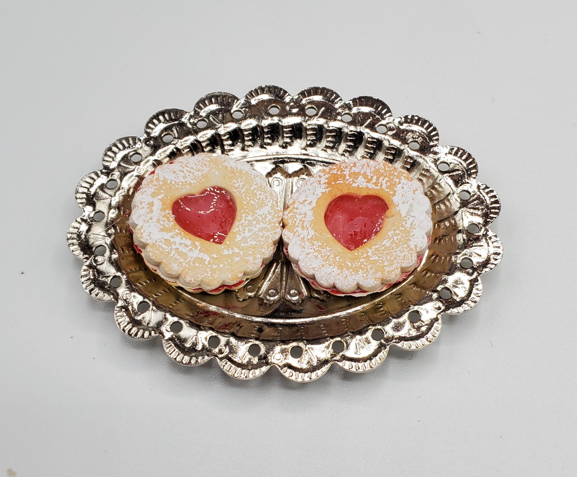 Chef Gina's mini Linzer cookies dolls with powdered sugar and red jam center on silver tray
