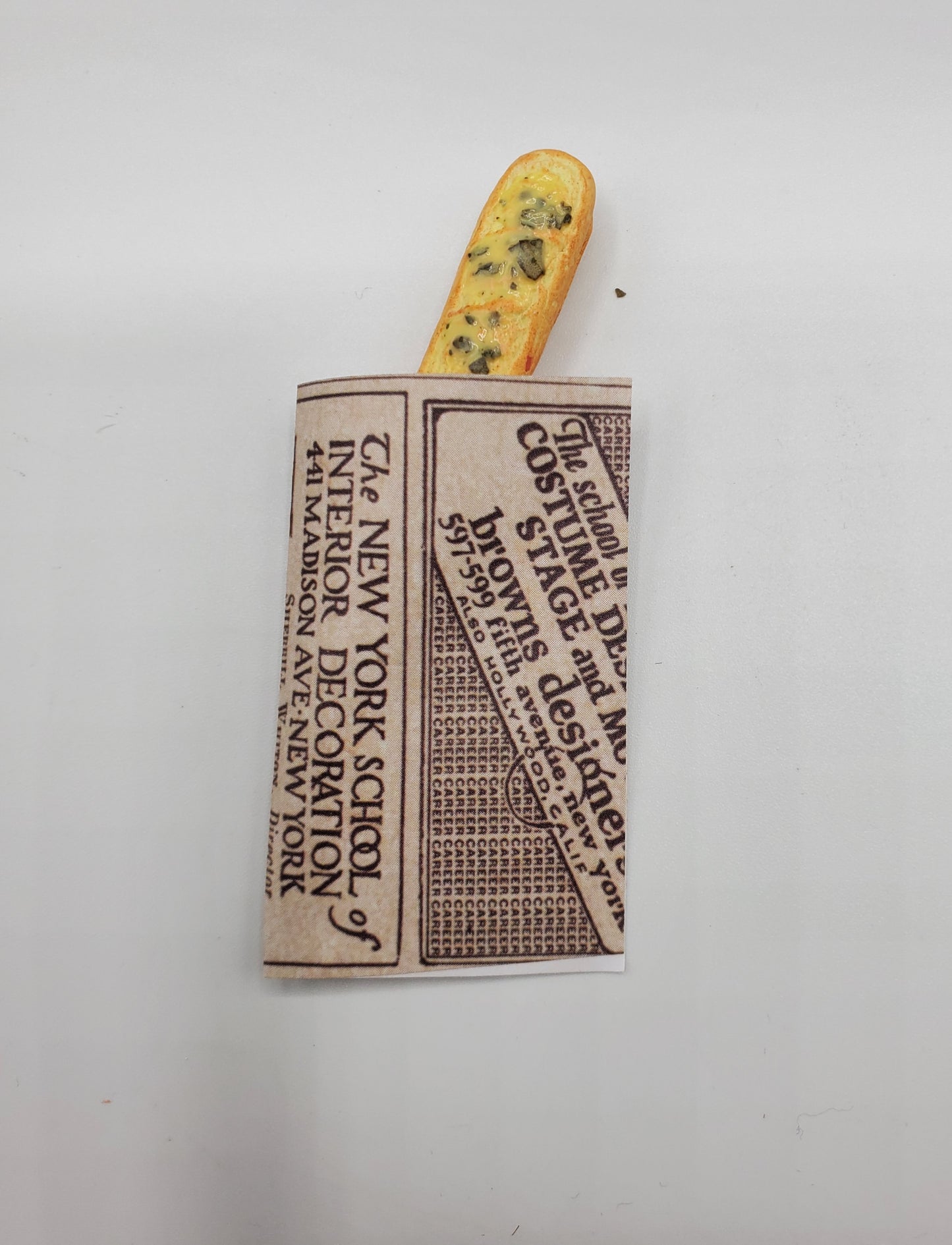 Chef Gina's miniature baguette bread wrapped in vintage newspaper style packaging
