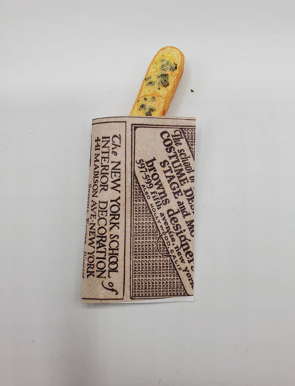 Chef Gina's miniature baguette bread wrapped in vintage newspaper style packaging