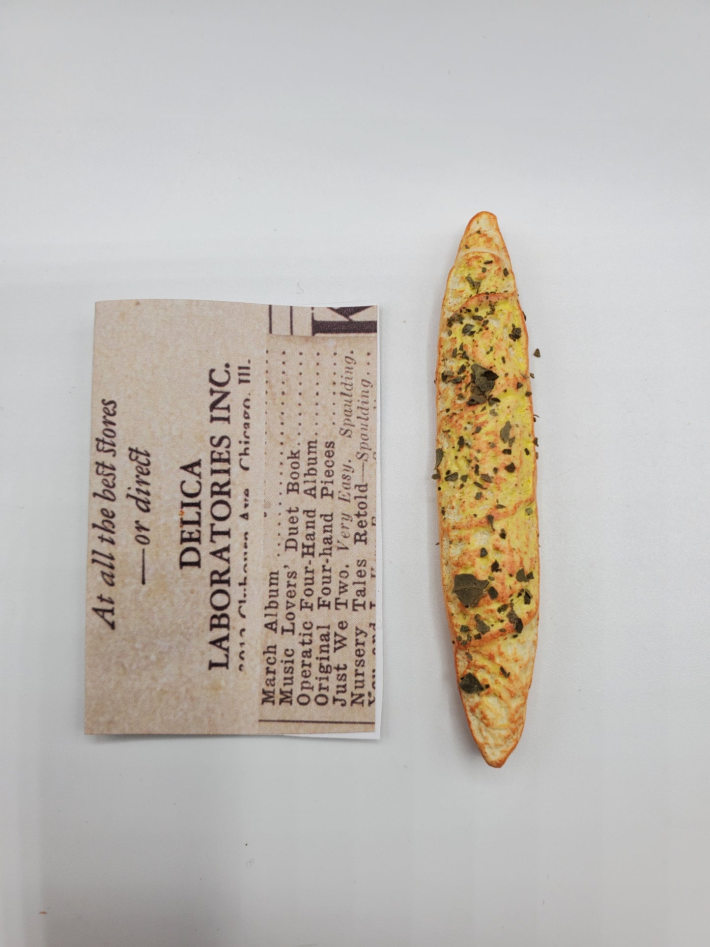 Chef Gina's miniature baguette bread with herbs and seasoning next to a Delica Laboratories Inc. label