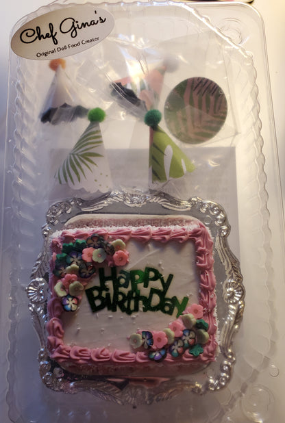 Chef Gina's miniature birthday party set cake with pink frosting and floral decorations in clear packaging