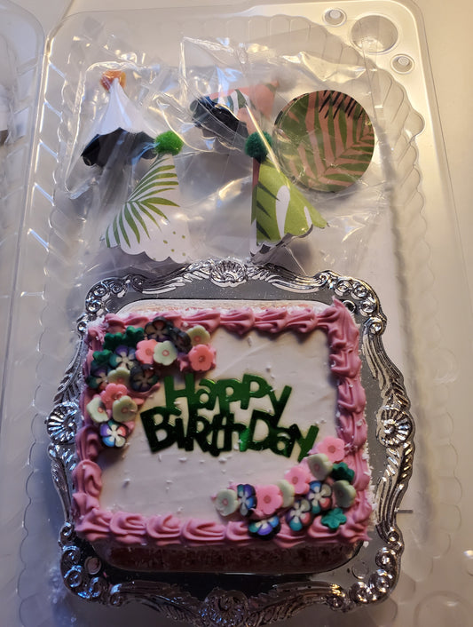 Miniature birthday party set featuring a small decorated cake with pink frosting and floral accents by Chef Gina's Mini Food