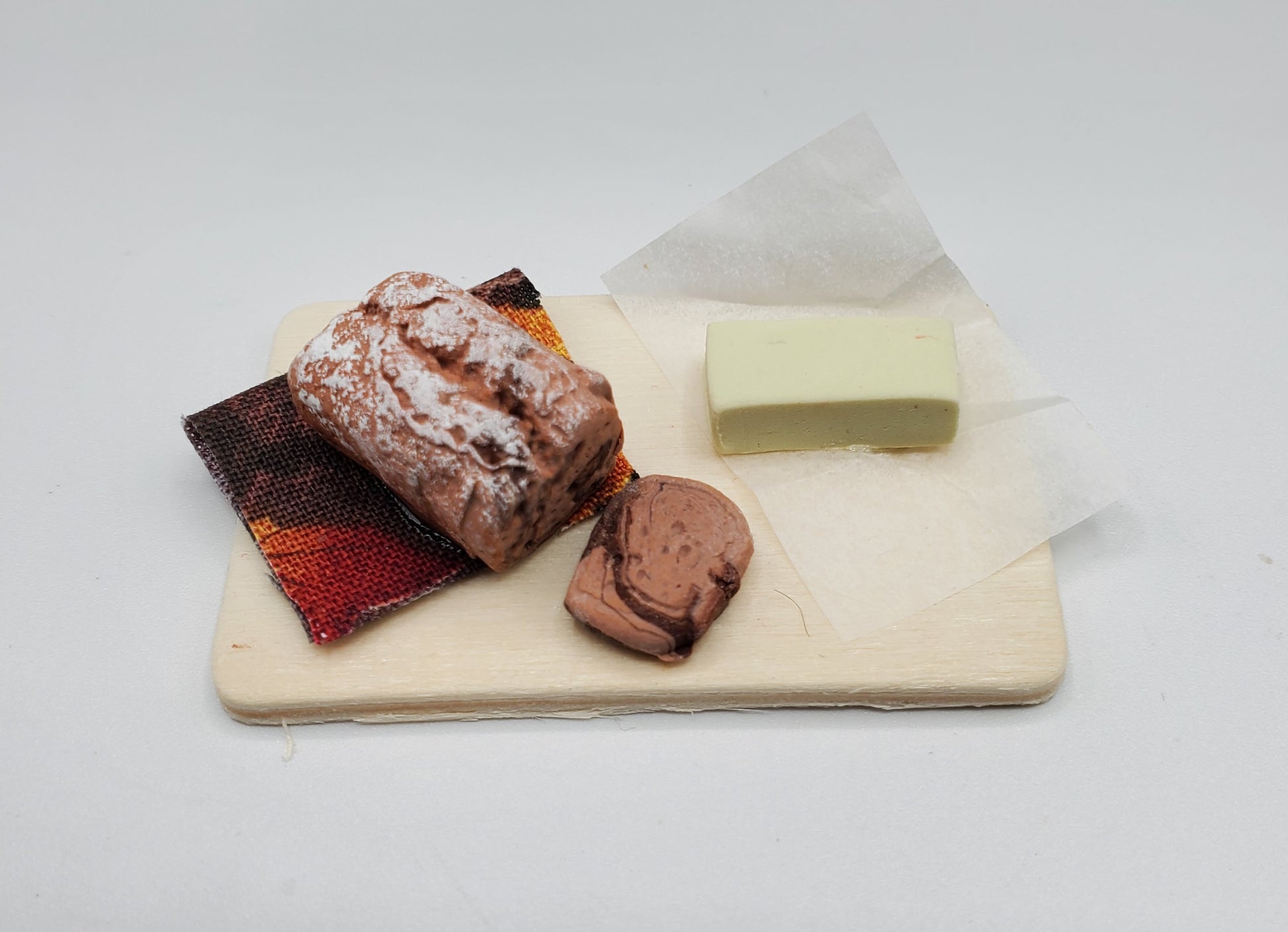 Chef Gina's miniature chocolate loaf bread with a slice and a small white block on a wooden board