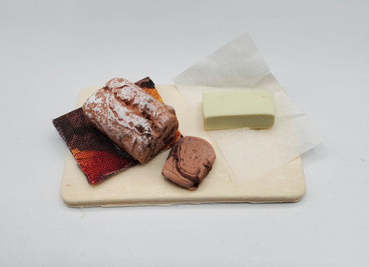 Chef Gina's miniature chocolate loaf bread with a slice and a small white block on a wooden board