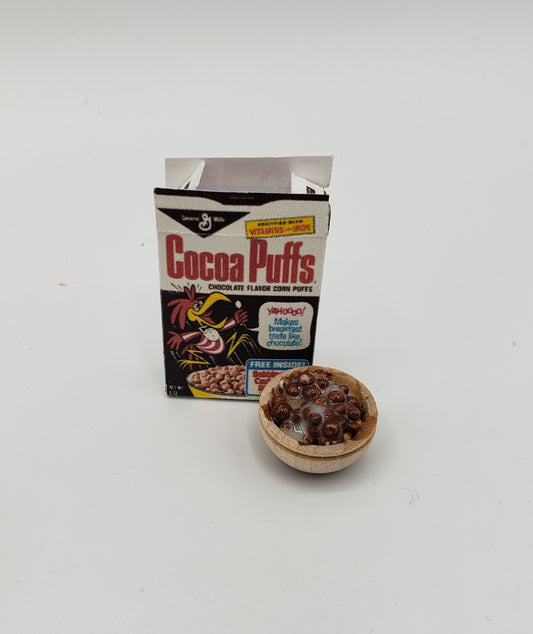 Miniature Coco Puffs cereal for dolls with a small open cereal box and a wooden bowl of chocolate puffs