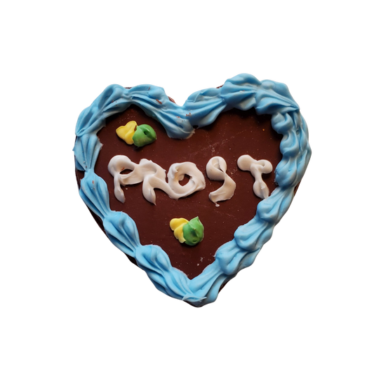 Miniature gingerbread heart cookie with blue icing border and frosted text saying Prost by Chef Gina's Oktoberfest