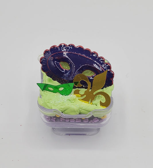 Chef Gina's miniature Mardi Gras torte dessert with colorful mask decorations and green frosting