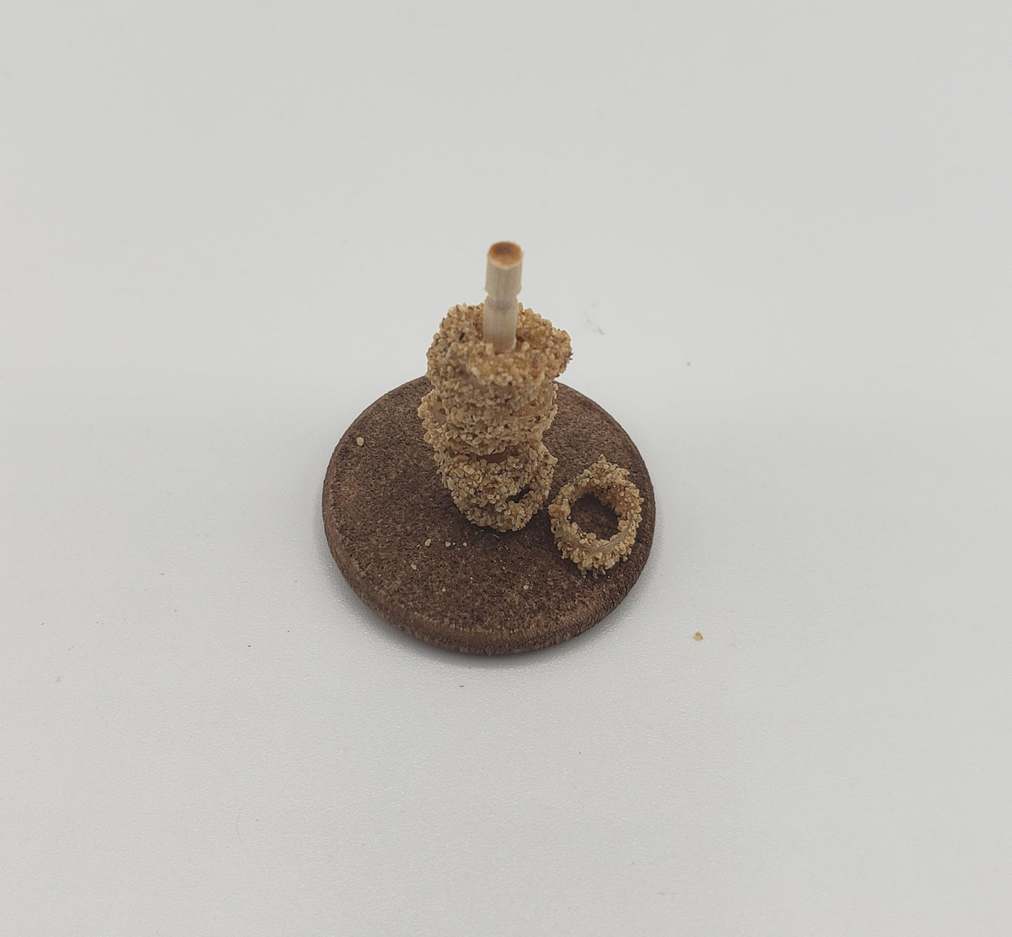 Chef Gina's miniature onion rings for dolls displayed stacked on a small rod on a round base