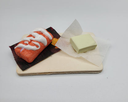 Chef Gina's miniature orange cream bread dessert with white icing on a small wooden board