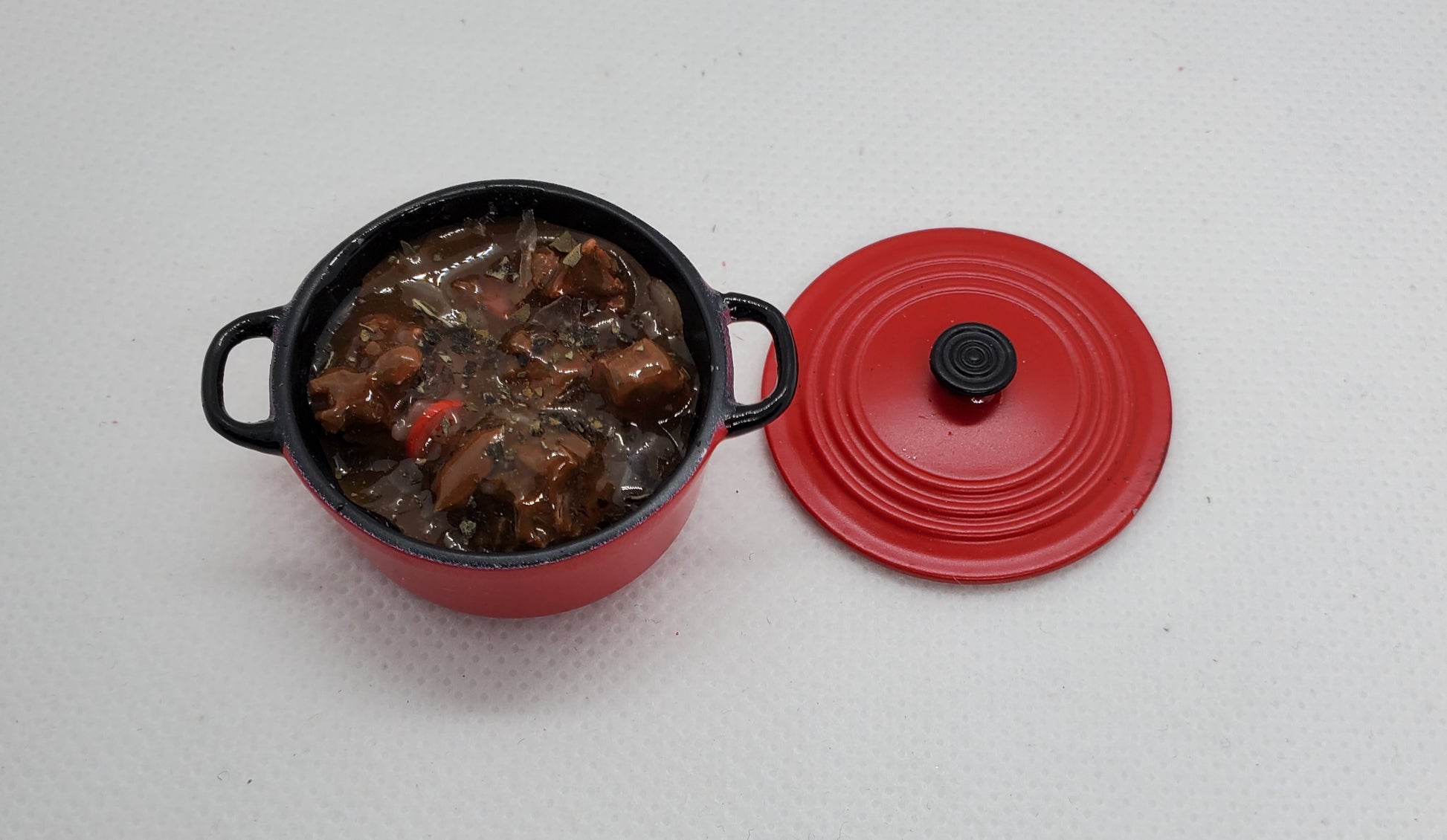 Chef Gina's miniature pot roast for dolls in a red mini cooking pot with lid off displayed