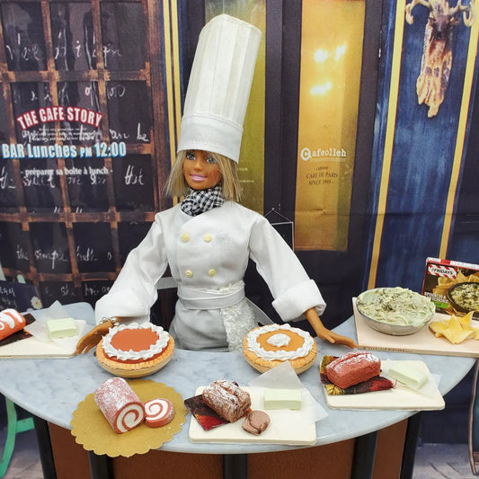 Chef Gina's® Mini Food display featuring a miniature pumpkin roll for dolls among various desserts