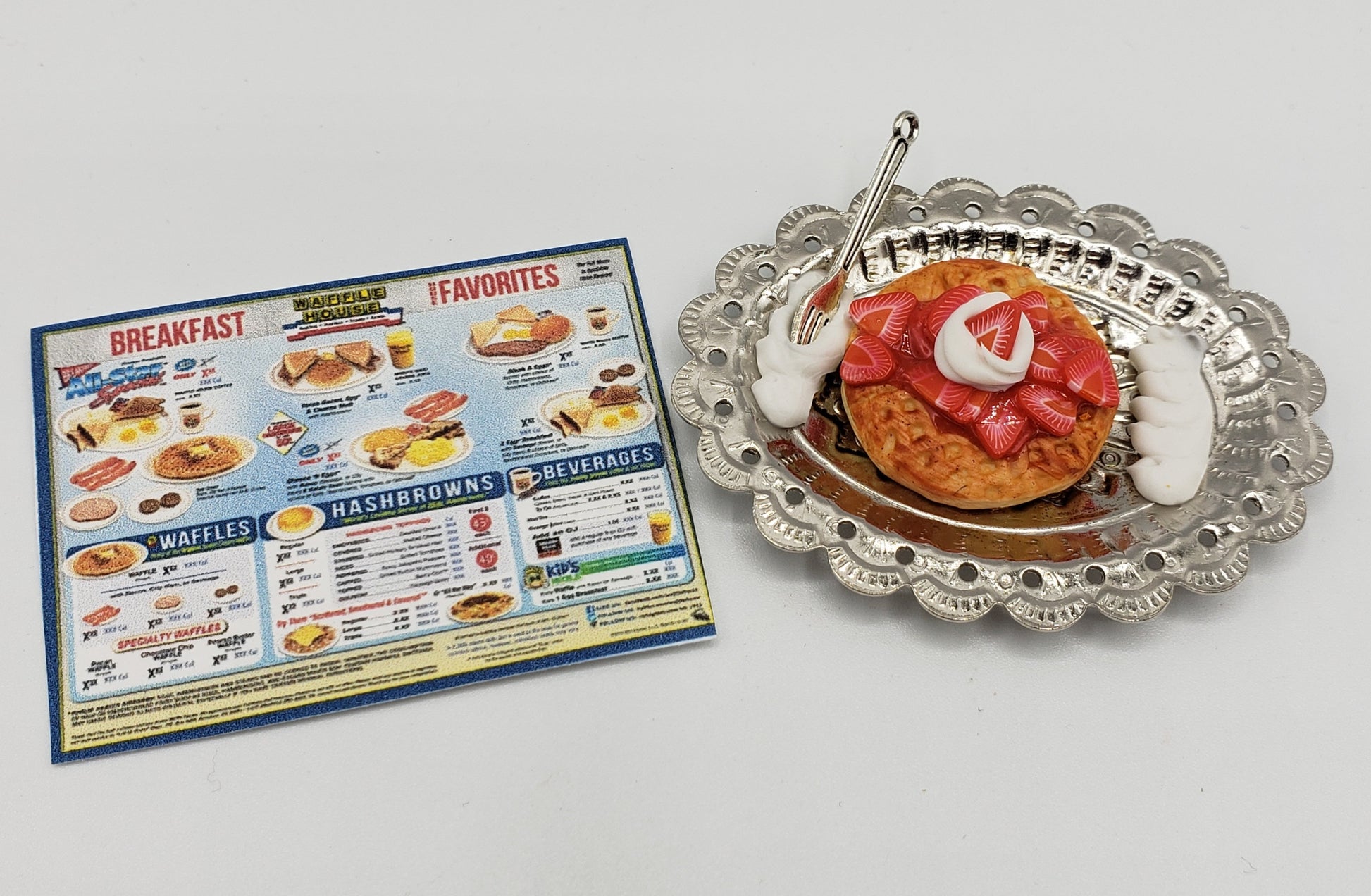 Miniature strawberry waffle for dolls with whipped cream on silver tray and breakfast menu card