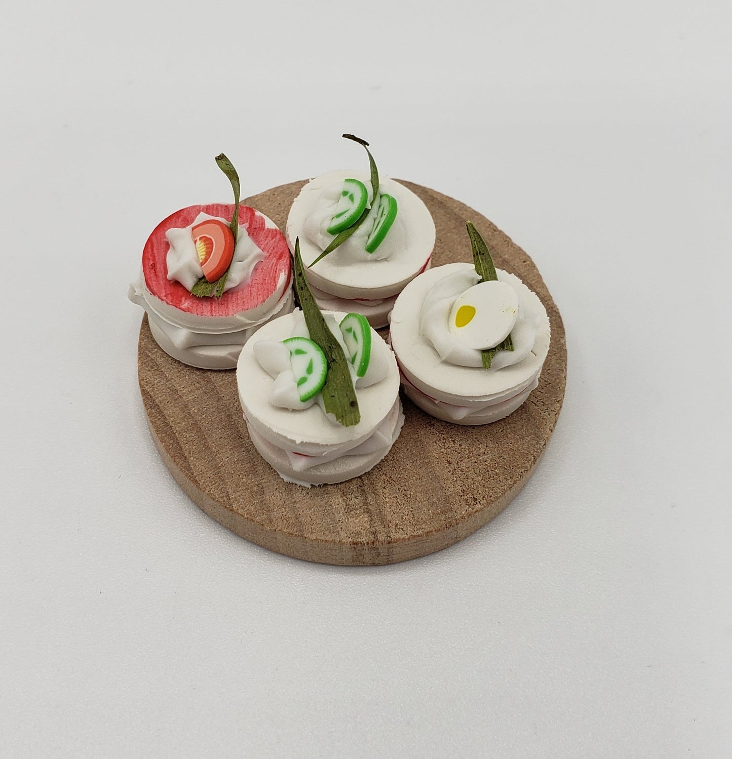 Chef Gina's miniature tea sandwiches on round wooden board with varied toppings