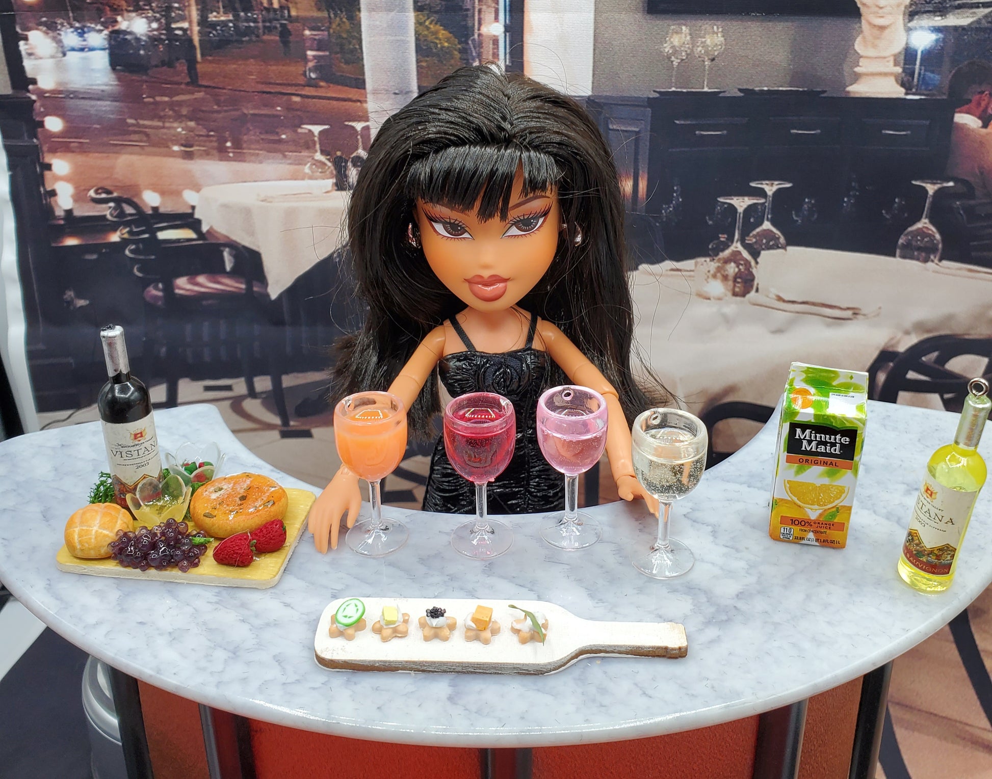 Miniature white wine for dolls displayed on table with doll and miniature food accessories