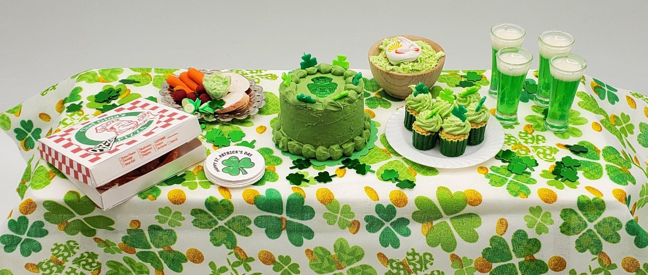 St. Patrick's Day-themed table setting with green clover pattern, cake, and drinks.