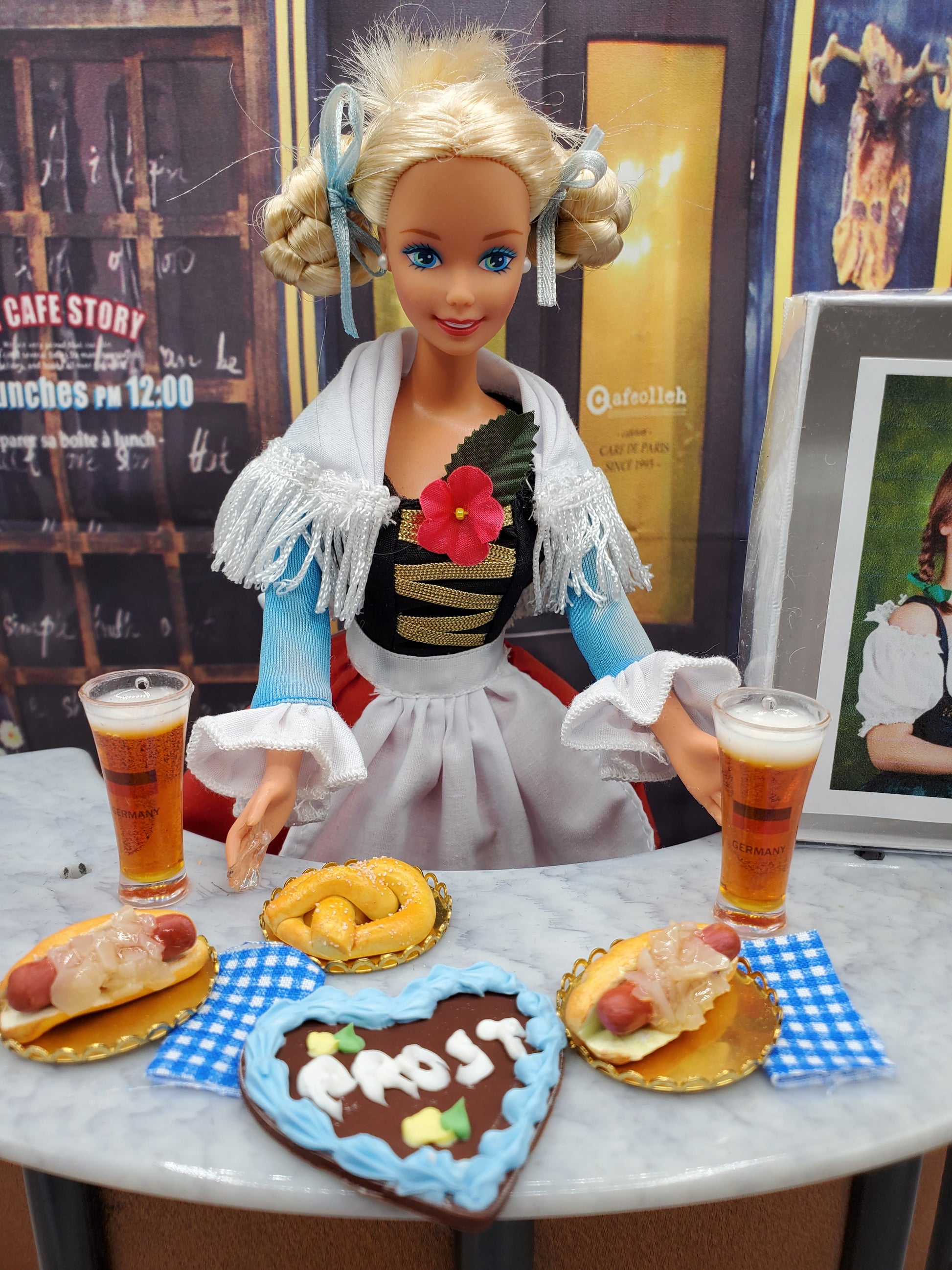 1:6 scale Oktoberfest doll food including pretzels, beer glasses, and sausage dishes with a doll in traditional costume