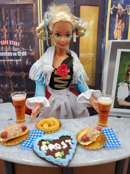 1:6 scale Oktoberfest doll food including pretzels, beer glasses, and sausage dishes with a doll in traditional costume