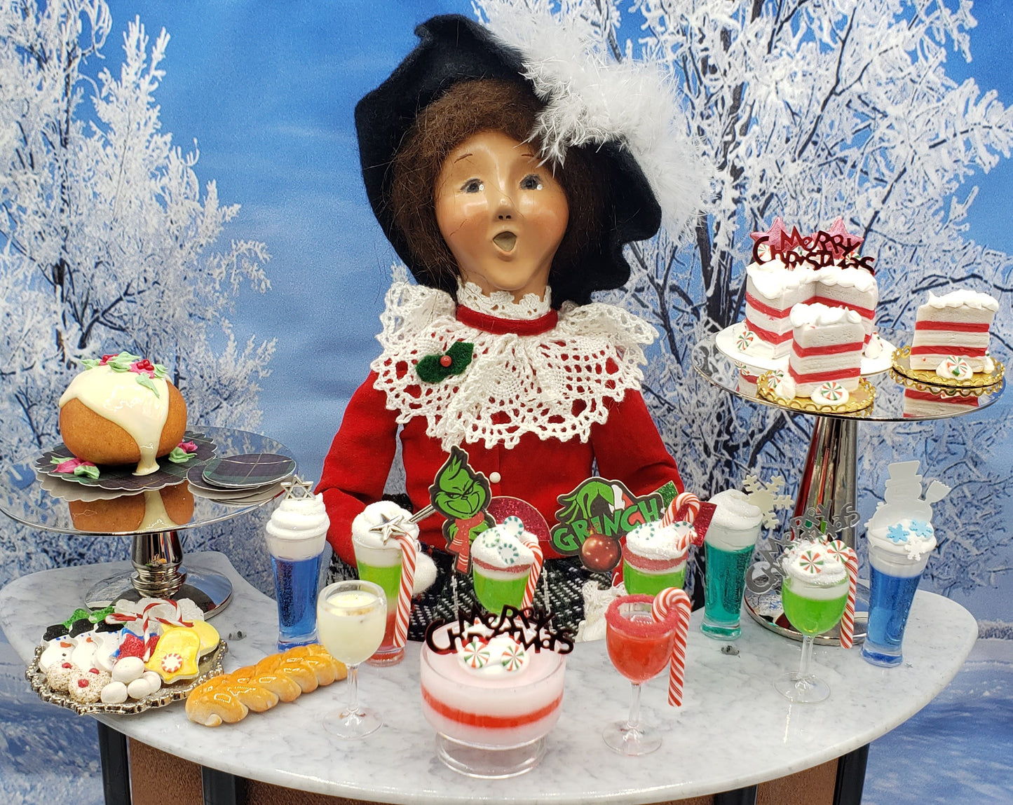 Chef Gina's Mini Food Grinch Christmas doll drink with festive holiday desserts on marble table