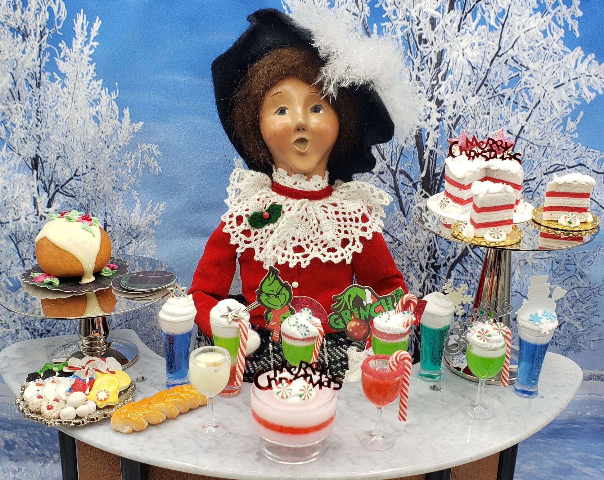 Chef Gina's Mini Food Grinch Christmas doll drink with festive holiday desserts on marble table