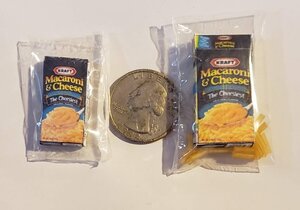 Miniature Kraft Macaroni and Cheese Boxes next to a Quarter for Size Comparison