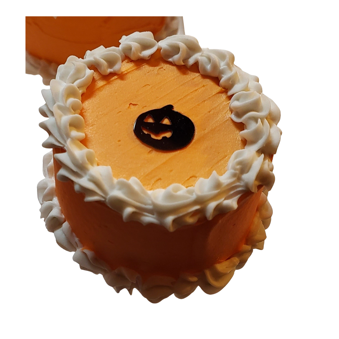 Mini Halloween cakes for dolls decorated with orange frosting and a pumpkin design