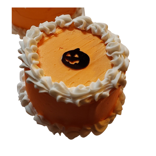 Mini Halloween cakes for dolls decorated with orange frosting and a pumpkin design