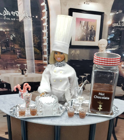 Mini hot chocolate bar for dolls with chef figure, candy canes, and hot chocolate display